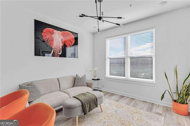 living room featuring an inviting chandelier and light hardwood / wood-style flooring