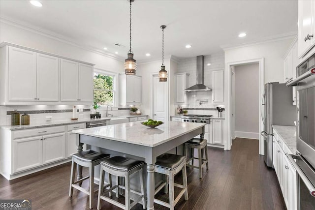 kitchen featuring white cabinetry, wall chimney exhaust hood, decorative backsplash, light stone countertops, and a kitchen island