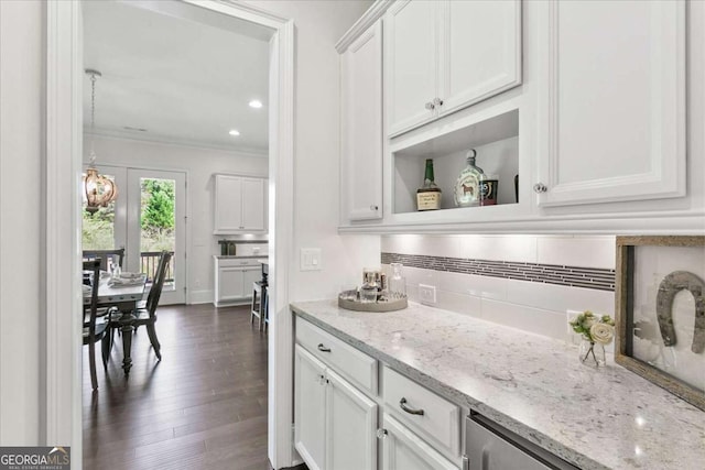 bar with light stone counters, dark hardwood / wood-style floors, decorative backsplash, white cabinets, and ornamental molding