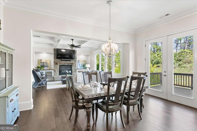 dining room featuring coffered ceiling, dark hardwood / wood-style flooring, ceiling fan with notable chandelier, beamed ceiling, and a stone fireplace