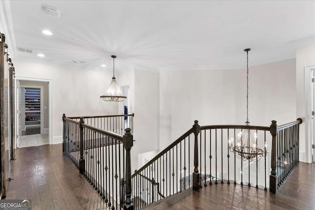 hall with a notable chandelier, crown molding, and dark hardwood / wood-style floors