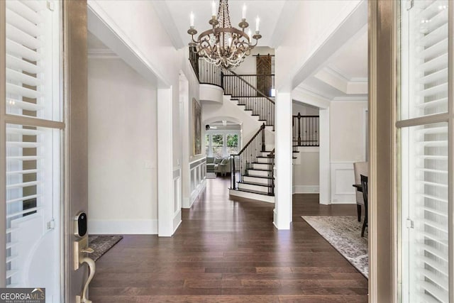 entrance foyer featuring radiator, dark wood-type flooring, an inviting chandelier, and crown molding