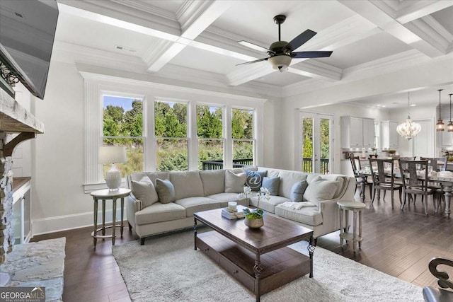 living room with dark wood-type flooring, beam ceiling, ceiling fan with notable chandelier, ornamental molding, and coffered ceiling