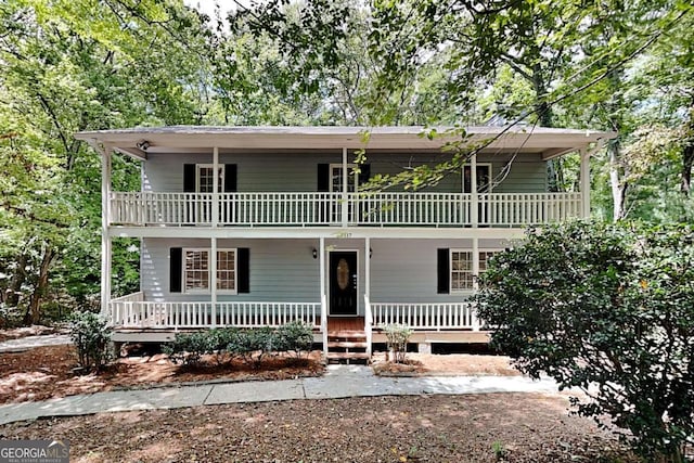 view of front property with covered porch and a balcony