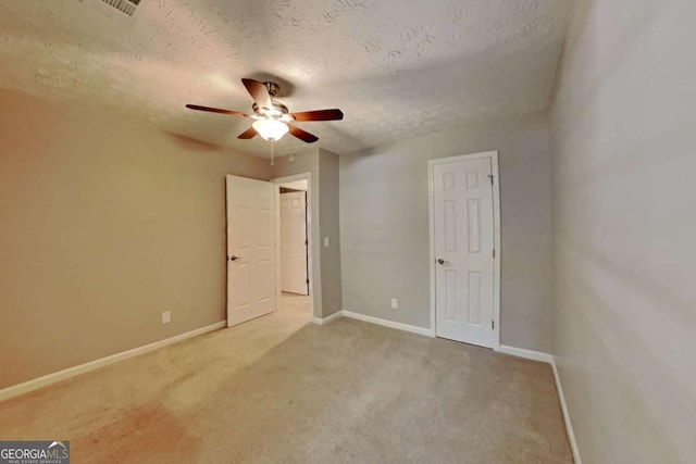 unfurnished bedroom featuring ceiling fan, carpet floors, and a textured ceiling