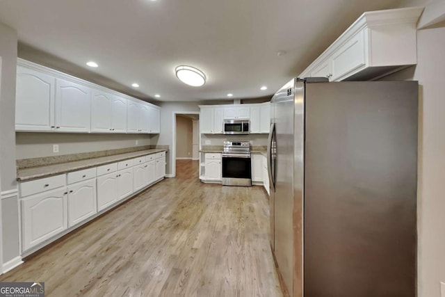 kitchen featuring white cabinetry, light wood-type flooring, and appliances with stainless steel finishes