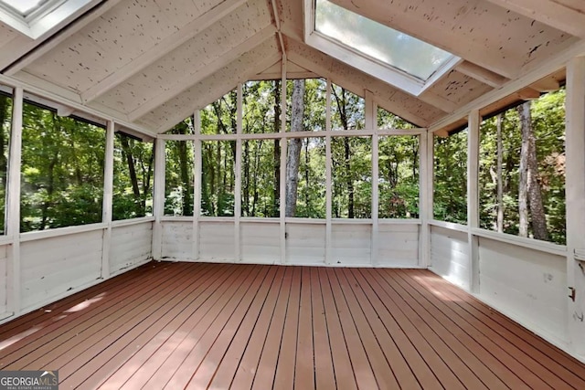 unfurnished sunroom featuring vaulted ceiling and plenty of natural light