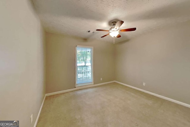 carpeted empty room featuring a textured ceiling