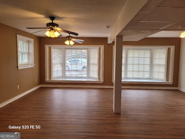 unfurnished living room with dark hardwood / wood-style flooring and ceiling fan