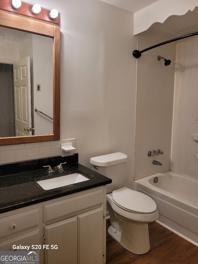 full bathroom with hardwood / wood-style flooring, toilet, backsplash, shower / bathing tub combination, and vanity