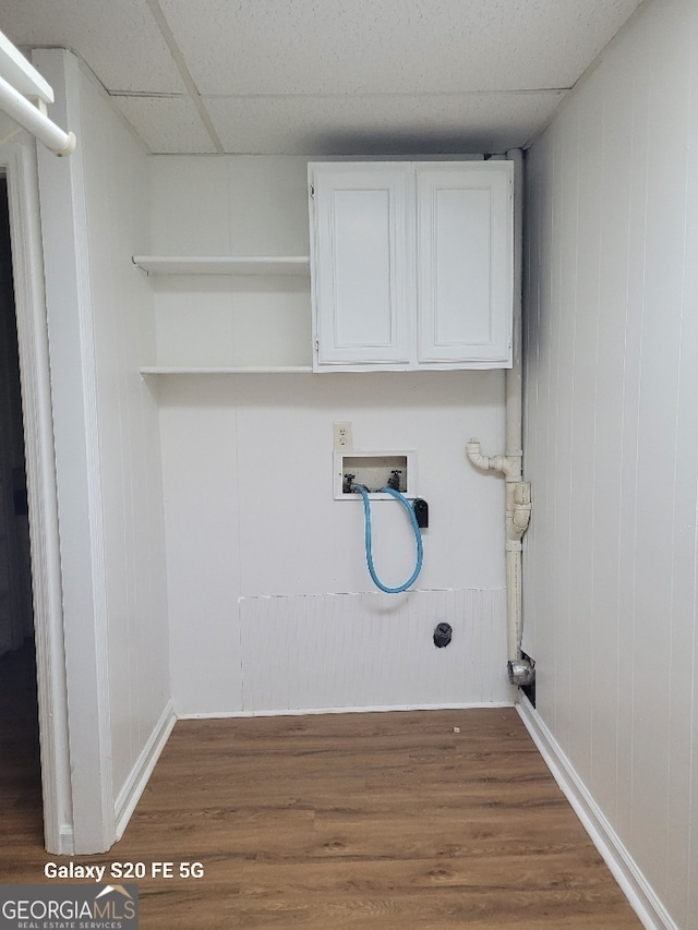 clothes washing area with dark hardwood / wood-style flooring, washer hookup, and cabinets