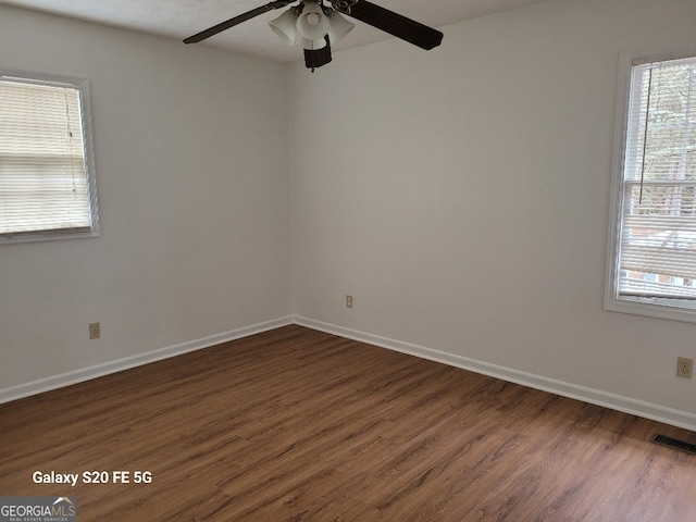 unfurnished room with ceiling fan and dark wood-type flooring