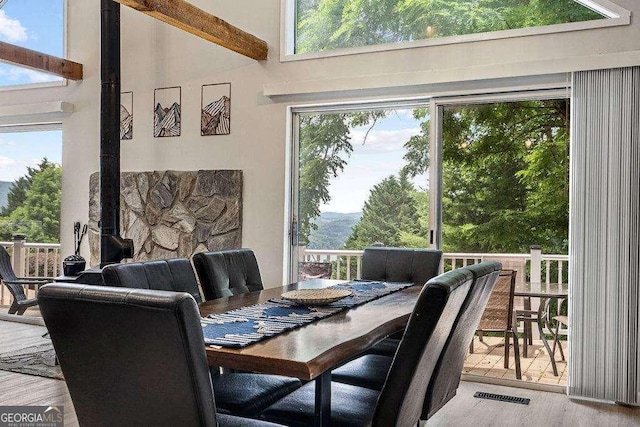 dining space featuring hardwood / wood-style floors, a high ceiling, and a wealth of natural light