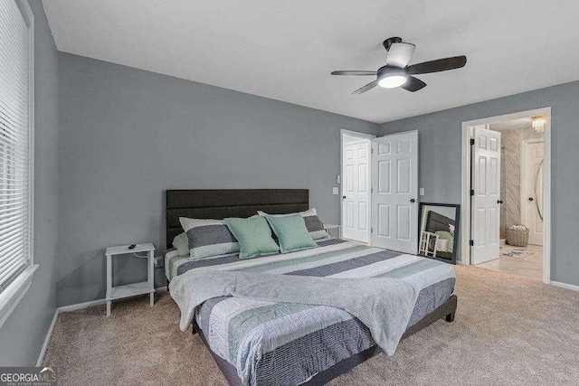 carpeted bedroom featuring ceiling fan and ensuite bath