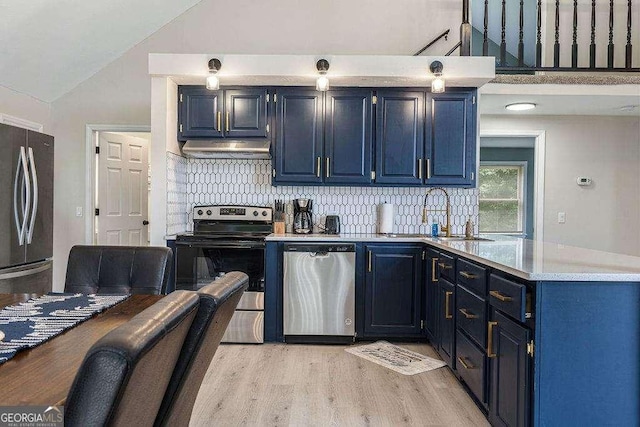 kitchen with blue cabinetry, appliances with stainless steel finishes, backsplash, light hardwood / wood-style floors, and vaulted ceiling