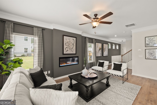 living room with ceiling fan, light hardwood / wood-style flooring, and crown molding