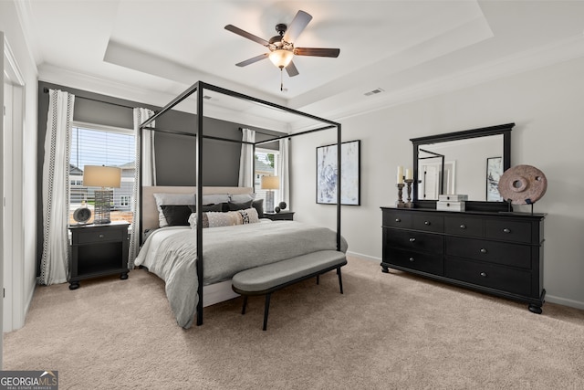 bedroom featuring a raised ceiling, ceiling fan, crown molding, and light carpet