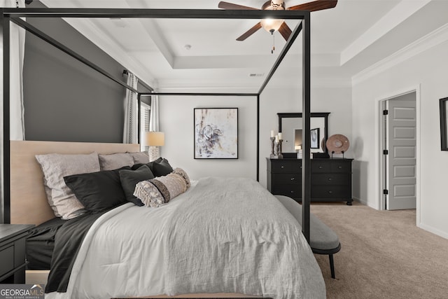 bedroom featuring crown molding, ceiling fan, a tray ceiling, and light carpet