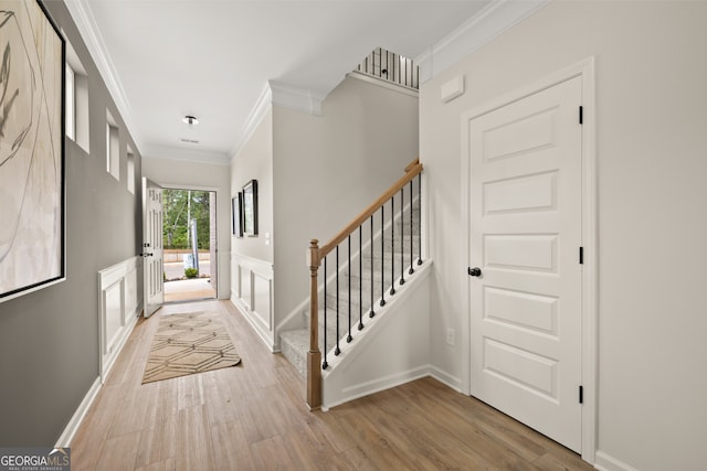 entryway featuring crown molding and light hardwood / wood-style flooring