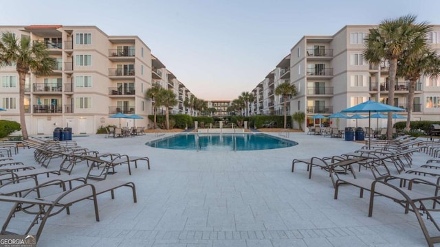 pool at dusk with a patio