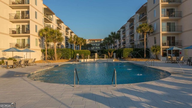 view of swimming pool featuring pool water feature and a patio area