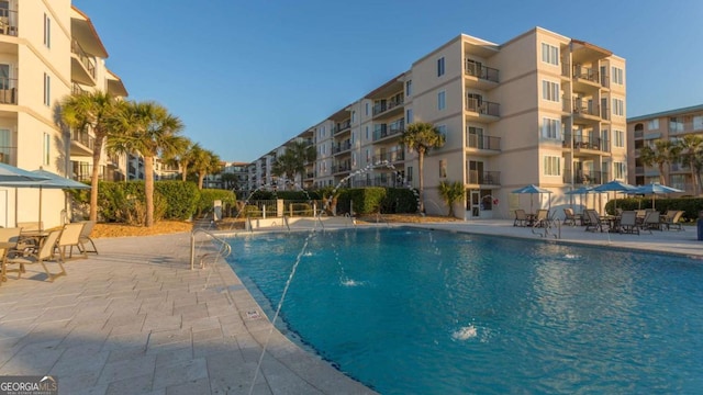 view of pool featuring pool water feature and a patio