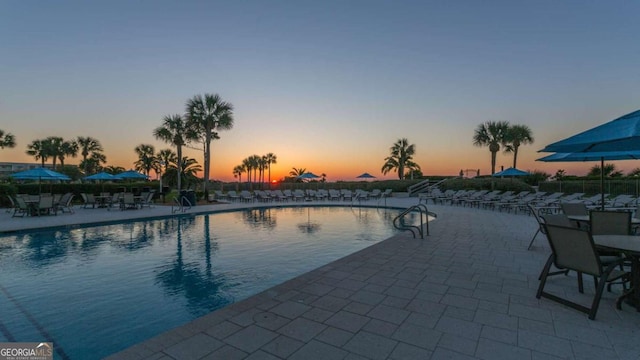 pool at dusk with a patio