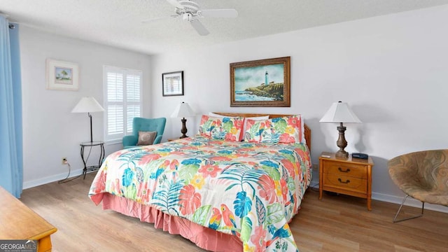 bedroom with ceiling fan, a textured ceiling, and hardwood / wood-style flooring