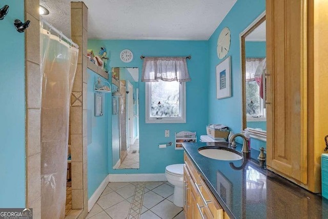 bathroom featuring tile patterned flooring, toilet, vanity, a textured ceiling, and curtained shower