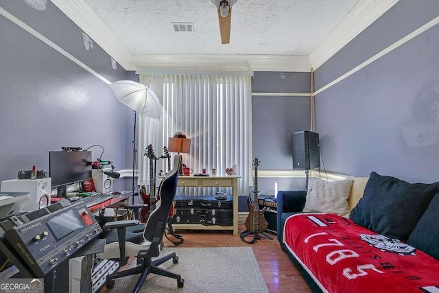 office area with a textured ceiling, hardwood / wood-style floors, ceiling fan, and ornamental molding