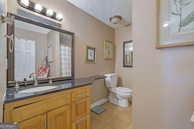 bathroom with a textured ceiling, tile patterned floors, vanity, and toilet