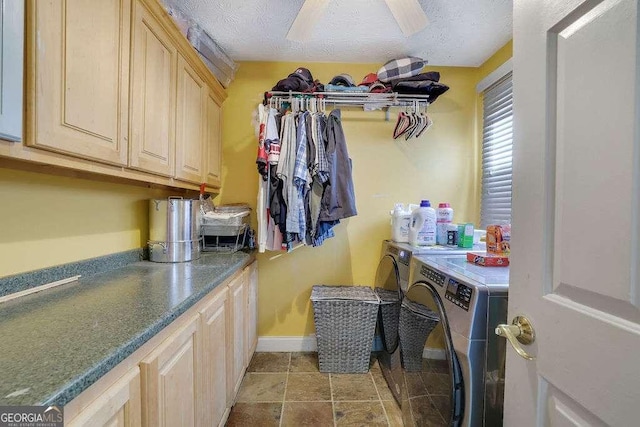 clothes washing area with a textured ceiling, separate washer and dryer, and cabinets