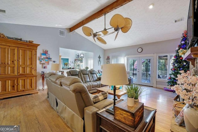 living room featuring light hardwood / wood-style floors, vaulted ceiling with beams, ceiling fan, french doors, and a textured ceiling