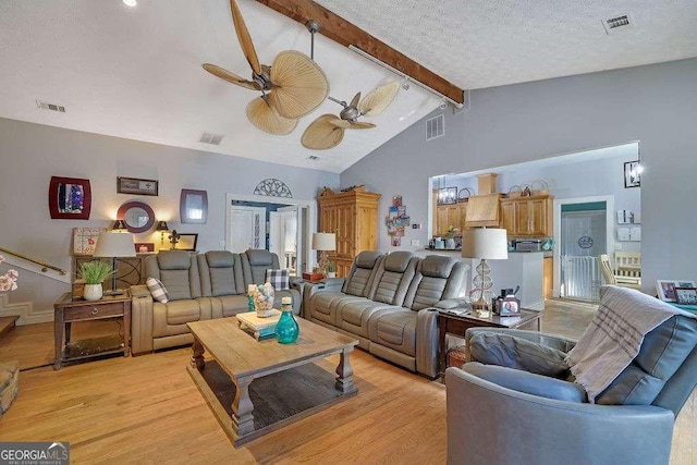 living room featuring a textured ceiling, ceiling fan, lofted ceiling with beams, and light hardwood / wood-style flooring