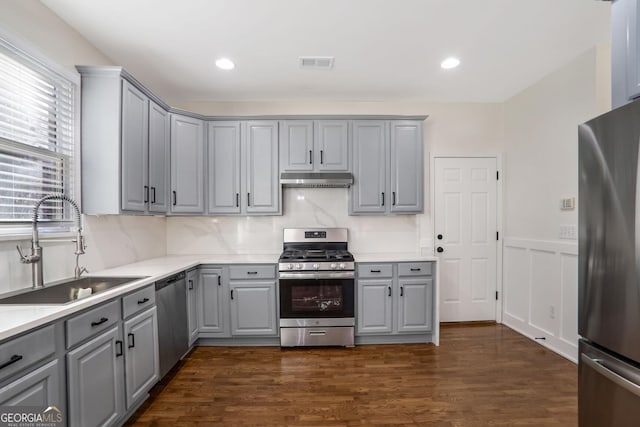 kitchen with sink, dark hardwood / wood-style floors, gray cabinetry, and appliances with stainless steel finishes