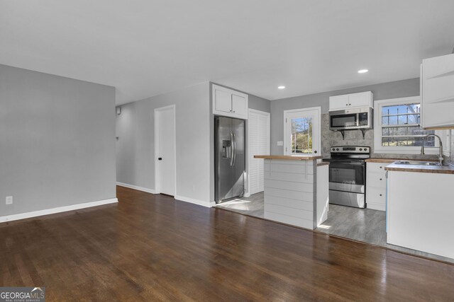 kitchen featuring appliances with stainless steel finishes, white cabinetry, and sink