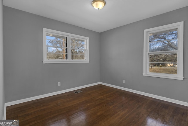 empty room featuring dark hardwood / wood-style flooring, wood walls, and a textured ceiling