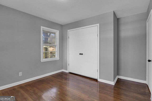 spare room featuring a textured ceiling, dark hardwood / wood-style flooring, and wood walls