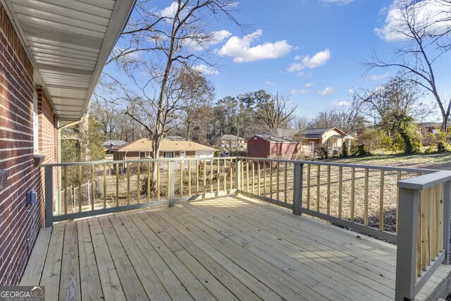 view of patio / terrace featuring a wooden deck and a storage unit