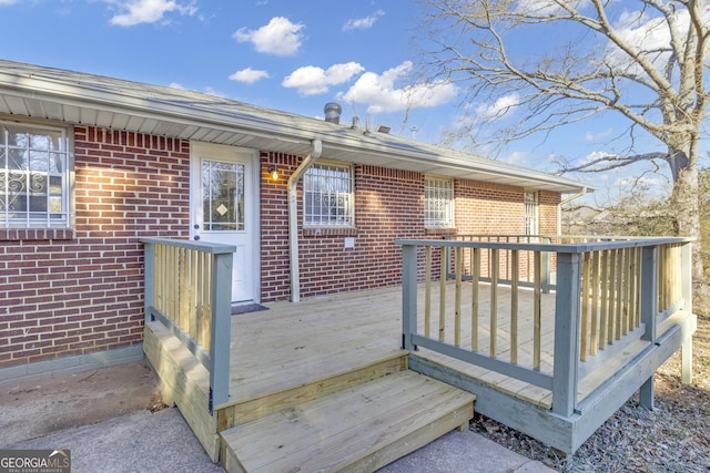 back of house featuring a wooden deck, a shed, a carport, and a yard