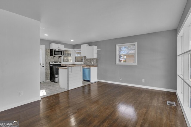 kitchen featuring white cabinetry, wooden counters, appliances with stainless steel finishes, decorative backsplash, and sink