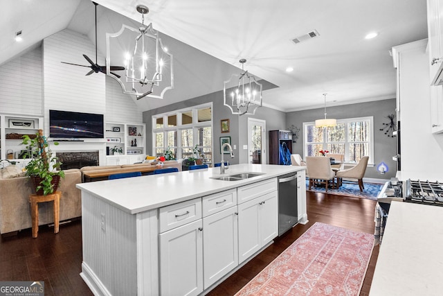 kitchen with sink, hanging light fixtures, an island with sink, and white cabinets