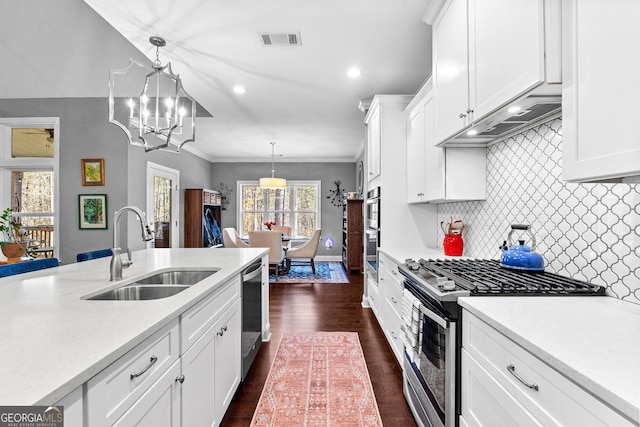 kitchen featuring a chandelier, hanging light fixtures, stainless steel appliances, white cabinets, and sink