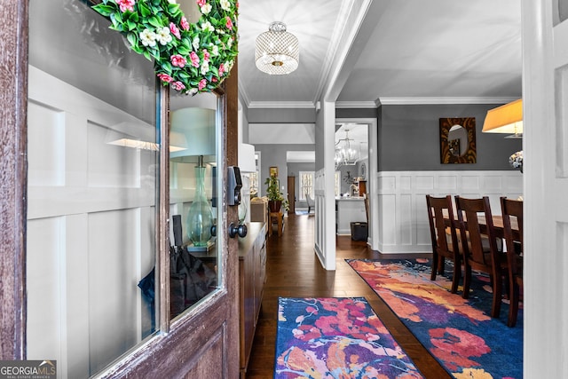 entryway with dark hardwood / wood-style flooring, a chandelier, and ornamental molding