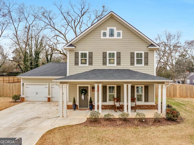 view of property with a porch, a garage, and a front yard