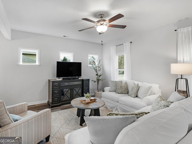 living room featuring plenty of natural light, ceiling fan, and light wood-type flooring