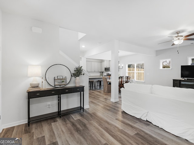 living room featuring ceiling fan with notable chandelier and hardwood / wood-style floors