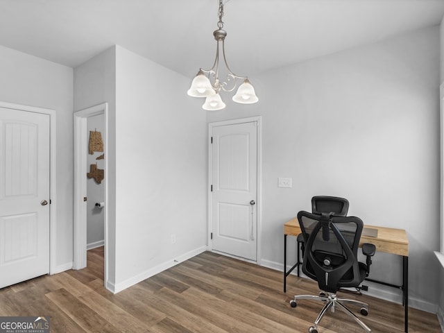 office with hardwood / wood-style flooring and an inviting chandelier