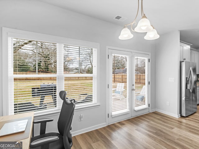 office area with light hardwood / wood-style flooring, a notable chandelier, and french doors