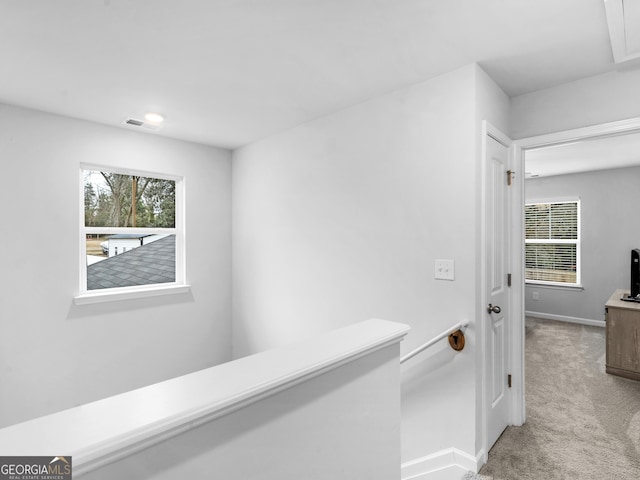 hallway featuring light colored carpet